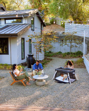 The Lotus Travel Crib set up in a family's backyard